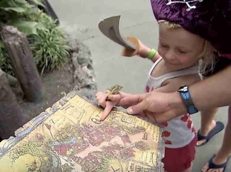 Niño leyendo mapa de Atraccion interactiva Pirata de los 7 mares